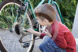 Little boy repair bicycle outdoor