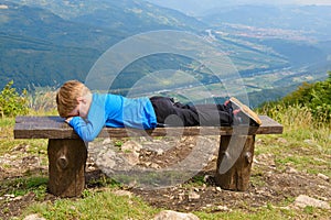 Little boy resting on a bench