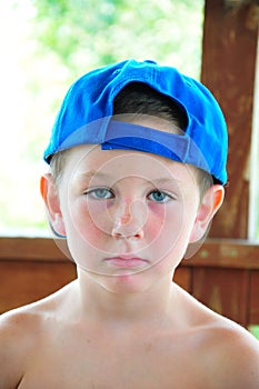 Little boy resting with his hat sideways