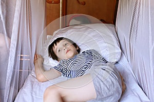 Little boy resting in the train compartment