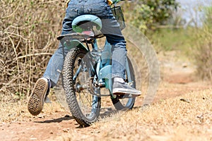 Little boy ride bicycle on the rock road.