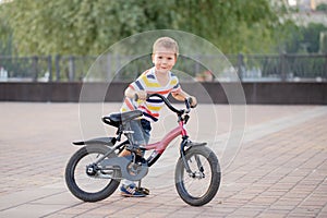 A little boy rides a Bicycle around the city