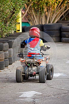 Little Boy Rides a Motorcycle ATV with Four Wheels. Outdoor Activity for Children on an Electric Racing Quad Bike Machine