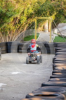 Little Boy Rides a Motorcycle ATV with Four Wheels. Outdoor Activity for Kid on an Electric Racing Quad Bike Machine