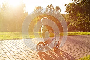 Little boy riding bike at sunset