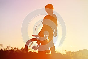 Little boy riding bike at sunset, kids sport