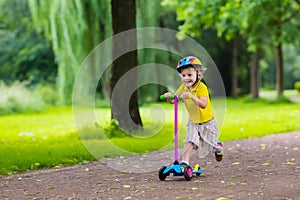 Little boy riding a colorful scooter