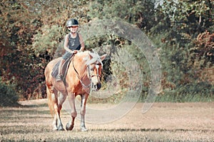 Little boy riding the horse.