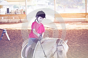 A little boy riding a horse. First lessons of horseback riding