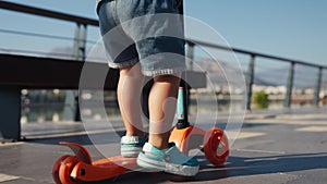 Little boy riding a kick scooter at the park