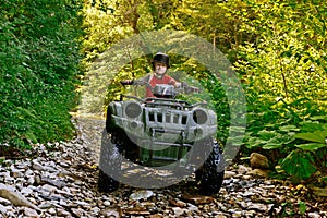 A little boy riding on a quad bike