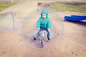 Little boy riding runbike in spring