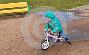 Little boy riding runbike in spring