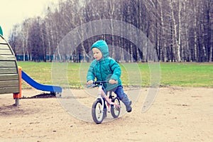 Little boy riding runbike in spring