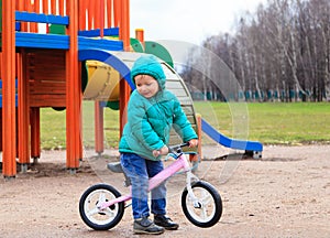 Little boy riding runbike in spring