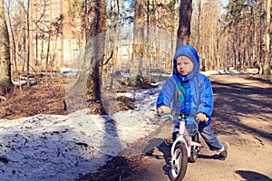 Little boy riding runbike in winter