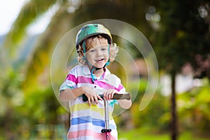 Little boy riding scooter. Kids ride kick board