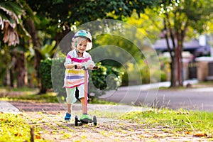 Little boy riding scooter. Kids ride kick board