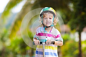 Little boy riding scooter. Kids ride kick board