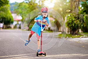 Little boy riding scooter. Kids ride kick board