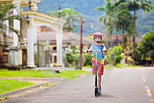 Little boy riding scooter. Kids ride kick board