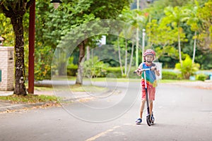 Little boy riding scooter. Kids ride kick board