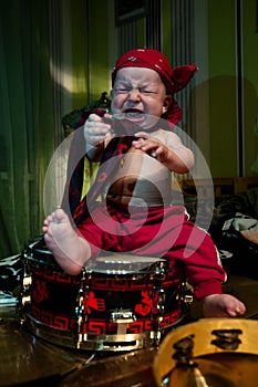 Little boy rocker drummer in red bandana and with drum