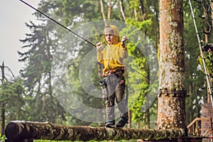 Little boy in a rope park. Active physical recreation of the child in the fresh air in the park. Training for children