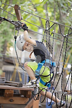 A little boy in a rope Park in the summer