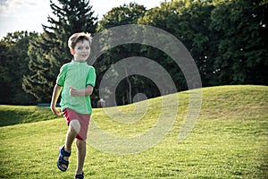 Little boy running on the grass on huge golf field