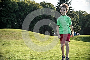Little boy running on the grass on huge golf field