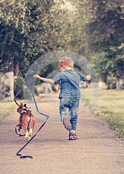 Little boy running with his beagle puppy