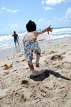 A little boy running into the ocean