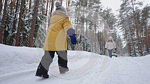 little boy is running to mother in snowy winter forest, happy meeting of child and mom