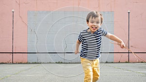 Little boy running towards camera on basque pelota court photo