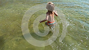 Little boy running in water.