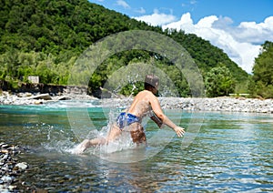 Little boy runs into the river with a run