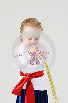 Little boy in Russian national costume blows in