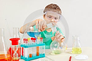 Little boy in safety goggles studies chemical practice in laboratory