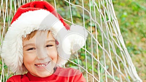 Little boy in santa hat resting on hammock. Christmas family vacation at tropical country. Christmas mood, dreaming, gifts