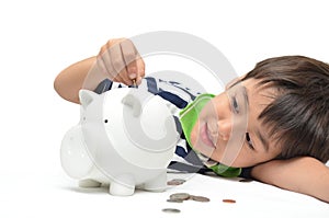 Little boy saving money in piggy bank
