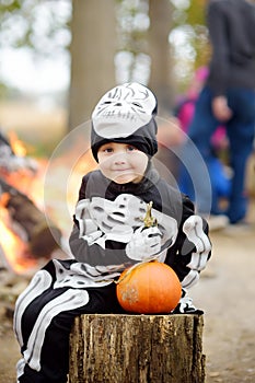 Little boy in scary skeleton costume at halloween celebrations party in forest