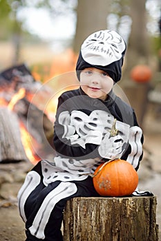 Little boy in scary skeleton costume at halloween celebrations party in forest