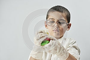 Little boy scientist in white making experiments