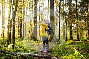 Little boy scout with binoculars during hiking in autumn forest. Child is looking through a binoculars. Concepts of adventure,