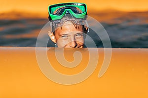 Little boy in scuba goggles, swimming and having fun in the pool. Summer vacation, sea