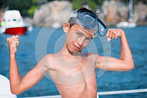 Little boy with scuba mask showing muscles