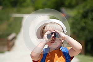 Little boy searching, searches with binoculars