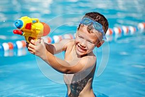 Little boy shooting with water gun