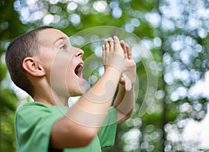 Little boy shouting in the forest